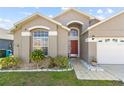 Charming single-story home featuring a well-manicured lawn and a two-car garage at 2422 Black Powder Ln, Kissimmee, FL 34743