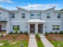 Stylish townhomes featuring a modern design with red doors, fresh landscaping and a sidewalk at 2573 Reading Trl, Kissimmee, FL 34746