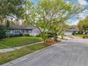 Charming single-story home with a manicured lawn and mature trees at 302 Log Run Ct, Ocoee, FL 34761