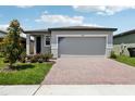 Attractive single-story home boasts a two-car garage, professional landscaping, and a brick paved driveway at 3189 Viceroy Ct, Poinciana, FL 34759