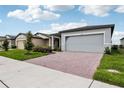 New home exterior showcasing a brick driveway, lush lawn, and 'Now Available' banner on the garage door at 3189 Viceroy Ct, Poinciana, FL 34759