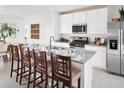 Modern eat-in kitchen with white cabinets, stainless steel appliances, and a granite countertop island at 3189 Viceroy Ct, Poinciana, FL 34759