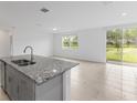 Modern kitchen island featuring a stainless steel sink and granite countertops at 3190 Viceroy Ct, Poinciana, FL 34759