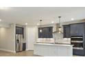 Modern kitchen featuring stainless steel appliances, a center island, and elegant dark blue cabinetry at 360 Birkdale Dr, Daytona Beach, FL 32124