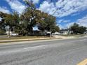 Neighborhood street view of well-maintained homes with mature trees and lush landscaping at 4007 Clarcona Ocoee Rd, Orlando, FL 32810