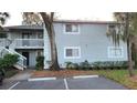 The exterior of a two-story condo shows mature landscaping and dedicated parking spots at 4164 Plantation Village Condos Dr # 504, Orlando, FL 32810