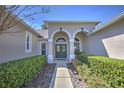 Inviting front entrance featuring a double door entryway, complemented by manicured landscaping and natural light at 4532 Saddleworth Cir, Orlando, FL 32826