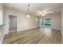 Spacious living area featuring wood floors, a ceiling fan, and natural light from the sliding glass doors at 4865 Cypress Woods Dr # 2105, Orlando, FL 32811