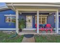 Inviting front porch area with colorful chairs, a small table and decorative plants at 5073 Lake Howell Rd, Winter Park, FL 32792