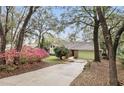 Charming single-story home with brick facade, green garage door, and mature landscaping at 5849 Groveline Dr, Orlando, FL 32810