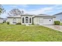 Charming single-story home with arched windows, light green exterior and attached two car garage at 609 Bluebill Ln, Kissimmee, FL 34759