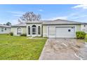 Charming single-story home with arched windows, light green exterior and attached two car garage at 609 Bluebill Ln, Kissimmee, FL 34759