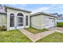 A close up of the front entrance with arched windows and a door with security system sign at 609 Bluebill Ln, Kissimmee, FL 34759