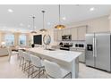 Modern kitchen with stainless steel appliances, a center island with seating, and pendant lighting at 6418 Tabebuia Pkwy, Winter Garden, FL 34787