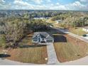 Stunning aerial view of a modern white home featuring a beautiful driveway and lush green surroundings at 6430 Sw 145Th Ln, Ocala, FL 34473