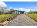 Beautiful single-story home boasting a paver driveway and a well-manicured front yard at 6430 Sw 145Th Ln, Ocala, FL 34473