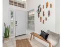 Bright foyer with a tiled floor, decorative wall art, and a wooden bench at 8121 Deville Ct, Orlando, FL 32817