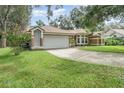 Charming single-story home with an attached garage, featuring a well-kept lawn at 8121 Deville Ct, Orlando, FL 32817