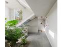 Hallway with tile floor, staircase, and tropical plants, creating a bright and airy atmosphere at 1109 Clubside Dr # 1109, Longwood, FL 32779
