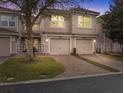 Charming townhouse featuring a tile roof, brick driveway, and well-maintained landscaping at 1205 Bella Rose Ct, Davenport, FL 33896