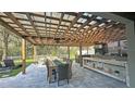 Spacious outdoor kitchen with a large patio, dining table, and stainless steel grill, perfect for entertaining guests at 13413 Hopkinton Ct, Windermere, FL 34786