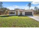 Beautiful one-story home with a lush green lawn and attached two car garage at 15163 Sw 29Th Terrace Rd, Ocala, FL 34473