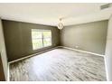 Spacious bedroom featuring wood-look floors and natural light from a large window at 1960 Fawn Meadow Cir, St Cloud, FL 34772