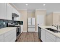 Modern kitchen features stainless steel appliances, white cabinetry, and a designer backsplash at 3771 Whitetail Ct, St Cloud, FL 34772