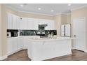 Bright kitchen with white cabinets, an island, modern appliances, and stylish backsplash at 3771 Whitetail Ct, St Cloud, FL 34772