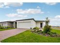 Inviting single-story home featuring a two-car garage, brick driveway, and professionally landscaped front yard at 4002 Copperleaf Ln, Poinciana, FL 34759