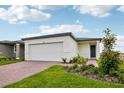 Inviting one-story home with a brick driveway, a two-car garage and a well-maintained lawn at 4002 Copperleaf Ln, Poinciana, FL 34759
