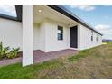 Exterior view of the back porch area, showing the brick pavement and a view of the lawn at 4002 Copperleaf Ln, Poinciana, FL 34759