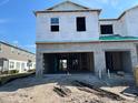 An exterior view of a new home under construction showcasing a two-car garage and the initial stages of building at 4315 Campsite Loop, Orlando, FL 32824