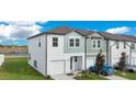 Attractive two-story home with a one-car garage, green lawn, and blue car parked in front at 509 Madison Dr, Davenport, FL 33837