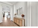 Hallway with wood flooring, a decorative console table with flowers, and an arched doorway at 5425 Bryce Canyon Dr, Kissimmee, FL 34758