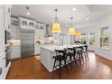 Bright, modern kitchen featuring stainless steel appliances, a large island, pendant lights, and hardwood floors at 8614 Hata St, Orlando, FL 32827