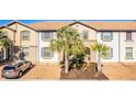 Charming townhouse with a well-manicured front yard featuring palm trees and ample parking space at 8879 Geneve Ct, Kissimmee, FL 34747