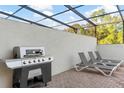 Covered patio area featuring a built-in grill and comfortable lounge seating, ideal for outdoor gatherings at 8879 Geneve Ct, Kissimmee, FL 34747