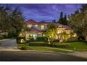 Elegant two-story home featuring a red tile roof, manicured landscaping, and decorative outdoor lighting at 9212 Island Lake Ct, Orlando, FL 32836