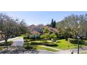 Stately two-story residence showcasing lush landscaping, a red tile roof, and a circular driveway at 9212 Island Lake Ct, Orlando, FL 32836
