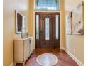 Elegant foyer with decorative wood floors, stylish entry door, and a modern console table at 10819 Woodchase Circle, Orlando, FL 32836