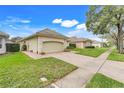 Street view showcasing the home with manicured lawn, brick driveway, and beige tile roof at 10819 Woodchase Circle, Orlando, FL 32836