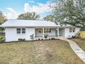 Inviting single-story home featuring a well-manicured front lawn and a sidewalk leading to the charming front porch at 1510 Live Oak St, New Smyrna Beach, FL 32168