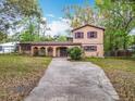 Inviting two-story home with a unique stucco facade, arched entry, and mature landscaping at 15523 Old Cheney Hwy, Orlando, FL 32828