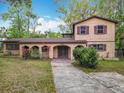 Inviting two-story home with a unique stucco facade, arched entry, and mature landscaping at 15523 Old Cheney Hwy, Orlando, FL 32828