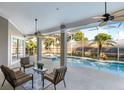 Covered patio with comfortable seating and ceiling fans, overlooking the inviting pool area at 235 Nob Hill Cir, Longwood, FL 32779