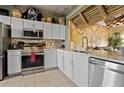 Kitchen featuring white cabinets, stainless steel appliances, marble countertops, and pirate themed decorations at 2511 Calabria Ave, Davenport, FL 33897