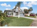 Beautifully landscaped two-story home with mature trees and a spacious front yard at 2570 Chatham Cir, Kissimmee, FL 34746