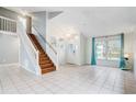 Bright and airy living room with tile floors, staircase, and large windows at 2570 Chatham Cir, Kissimmee, FL 34746