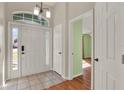 Bright foyer featuring tile flooring and large windows above the front door, complemented by a view into the living area at 3200 Utah Dr, Deltona, FL 32738